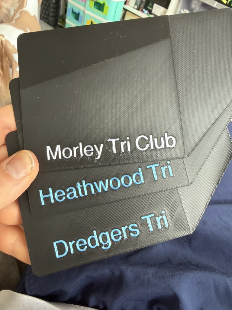 Custom black bike plates with club names in white and blue text